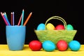 Easter bright composition holding painted Easter eggs and coloured crayons