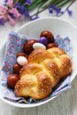 Easter bun, colored eggs and flowers on a white background