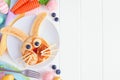 Easter Bunny pancake breakfast, side border with copy space against white wood Royalty Free Stock Photo