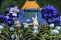 Easter bunny camping in field of blue Easter eggs and blue tent