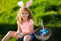 Easter egg hunt. Easter bunny child boy with cute face. Kids hunting easter eggs. Cute child with easter basket on grass