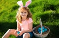 Easter egg hunt. Easter bunny child boy with cute face. Kids hunting easter eggs. Cute child with easter basket on grass