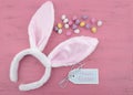 Easter bunny ears with Easter eggs on pink wood