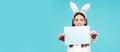 Easter bunny girl hold paper for text. Easter bunny rabbit - copy space, text concept. Empty paper. Panoramic web banner