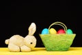 Easter bunny and green basket with colourful painted eggs