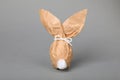 Easter bunny made of kraft paper and egg on grey background