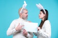 Easter bunny. Man and woman with board for text. Couple dressed in costume Easter bunny on blue background isolated. Royalty Free Stock Photo