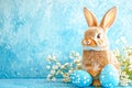 Easter bunny rabbit with blue painted egg on blue background. Easter holiday concept Royalty Free Stock Photo