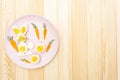 Easter bunny rabbit and chicken eggs children kids food concept. With carrot on rosy pink plate. Wooden background Royalty Free Stock Photo