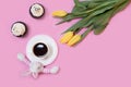 Easter bunny rabbit, white coffee cup, cakes and spring tulip flowers on pink background. Flat lay, copy space for text. Happy Royalty Free Stock Photo