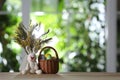 Easter bunny toy, dyed eggs and flowers on table against blurred green background. Space for text Royalty Free Stock Photo