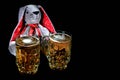 Easter bunny with two mugs of beer against black background