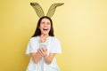 Easter bunny woman with bright emotions on yellow studio background Royalty Free Stock Photo