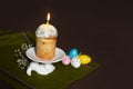 Easter cake with burning candles with colored eggs on a stand in the form of a hare Royalty Free Stock Photo