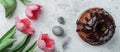 Easter cake with chocolate on white background with Easter eggs, nest and pink tulips flowers. Happy Easter holiday, top view Royalty Free Stock Photo