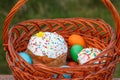 Easter cake and colorful Easter eggs in wicker basket Royalty Free Stock Photo