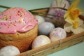 Easter cake and eggs with daffodils on a wooden platter