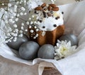 Easter cake and gray painted eggs in a basket decorated with white flowers. Royalty Free Stock Photo