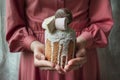 Easter cake in the hands of a young girl in a pink dress. Easter, Easter cake decorated with chocolate products and marshmallows.