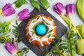 Easter cake in icing sugar painted eggs and tulips on the table. Top view close up Royalty Free Stock Photo