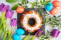 Easter cake in icing sugar painted eggs and tulips on the table. Top view close up Royalty Free Stock Photo