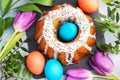 Easter cake in icing sugar painted eggs and tulips on the table. Top view close up Royalty Free Stock Photo
