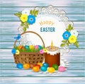 Easter cake kulich with candle, basket, easter eggs on wooden background - Orthodox Easter greeting card.