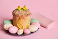 Easter cake, panettone and colorful eggs near red checkered napkin, on pink background. Easter celebration concept