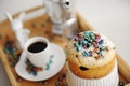 Easter cake sprinkled colored pearl coffee beans close up. Espresso maker moka pot and cup of coffee on the background Royalty Free Stock Photo