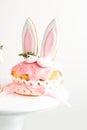 Easter cake, sweet bread decorated with bunny ears cookies, sugar icing and meringues. Kulich wrapped in a craft paper on the