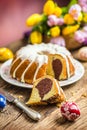 Easter Cake. Traditional ring marble cake withe easter decotation. Easter eggs and spring tulips.