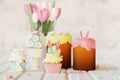 Easter cakes, cupcakes, eggs and gingerbread cookies on white wooden table. 3d render