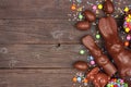 Easter candy, chocolate bunny and egg side border against a dark wood background Royalty Free Stock Photo