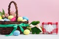Easter card. Basket with eggs toy rabbit gift on the table on a pink background Royalty Free Stock Photo
