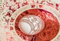 Easter card with egg and white openwork oval frame on coral background, Bright sunlight creates beautiful shadows on white egg,