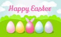 Easter card. On the green field are painted eggs, behind one of them stick bunny ears. Royalty Free Stock Photo