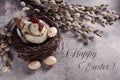 Easter card with a hen figurine in the nest  on beton concrete wall background with greeting text Royalty Free Stock Photo