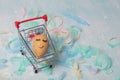 Easter card made of feathers and an egg with a painted cute face in an ER grocery basket Royalty Free Stock Photo