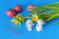 Easter card with red eggs, narcissus flowers and two angels communicating. Blue color. happy Easter. soft focus