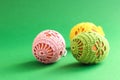Easter cards: three Easter eggs decorated with a handmade knitted pattern on a green background, space for text