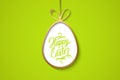 Easter celebrate banner with golden easter egg and handwritten holiday wishes of a Happy Easter on green background.