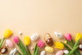 Top view photo of colorful easter eggs small baskets ceramic bunnies yellow and pink tulips on pastel beige background Royalty Free Stock Photo