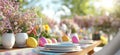 Easter celebration table setting with flowers and colorful eggs in sunny garden Royalty Free Stock Photo