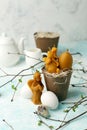 Easter celebration table setting, stylized photo - eggs and decorative natural wax candles - angel, rabbit, egg on light