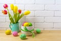 Easter centerpiece with decorated eggs, green ribbon and tulips