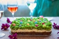 Easter cheesecake decorated with little colourful sweet eggs on top of green moss like layer.