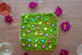 Easter cheesecake decorated with little colourful sweet eggs on top of green moss like layer.