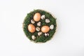 Easter.Chicken eggs and quail eggs lie in a basket with moss on a white background, top view. Spring, April