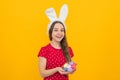 Easter child holidays concept. Happy smiling little teenage girl with bunny ears holding painted easter eggs. Royalty Free Stock Photo