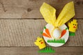 Easter children card concept with egg in bunny nupkin, white plate and paper craft diy decorative chikens on wooden background